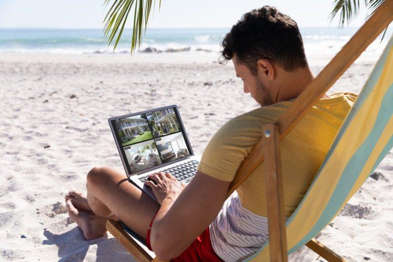 Man On Holiday Using laptop to view security camera